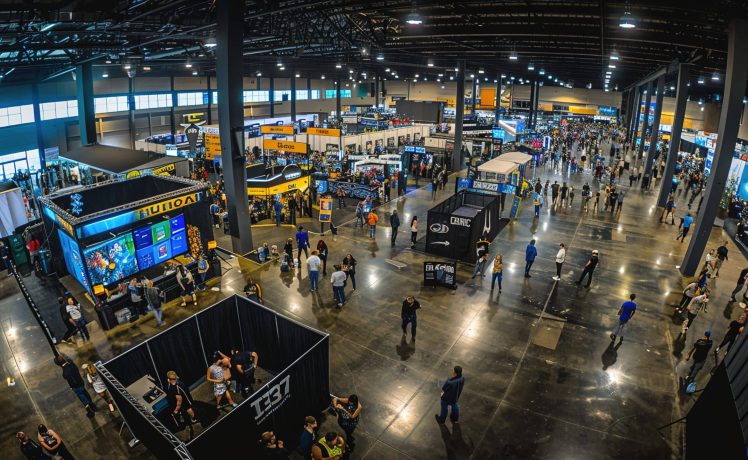 A panoramic shot of a bustling tech conference or expo, with attendees exploring the latest gadgets and innovations --ar 16:9 Job ID: 9bdd74e2-fc07-4426-9ee9-4dfb9c7beca1